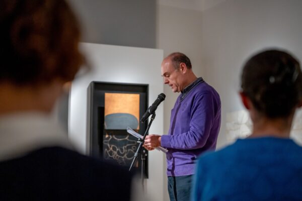 Man reading poem at an open mic event